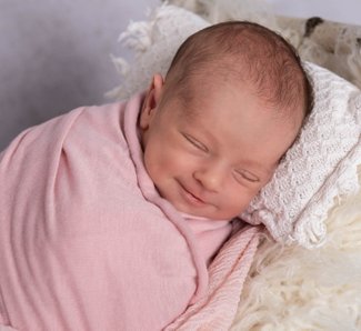 Newborn-Baby-Mädchen-rosa-Lächeln